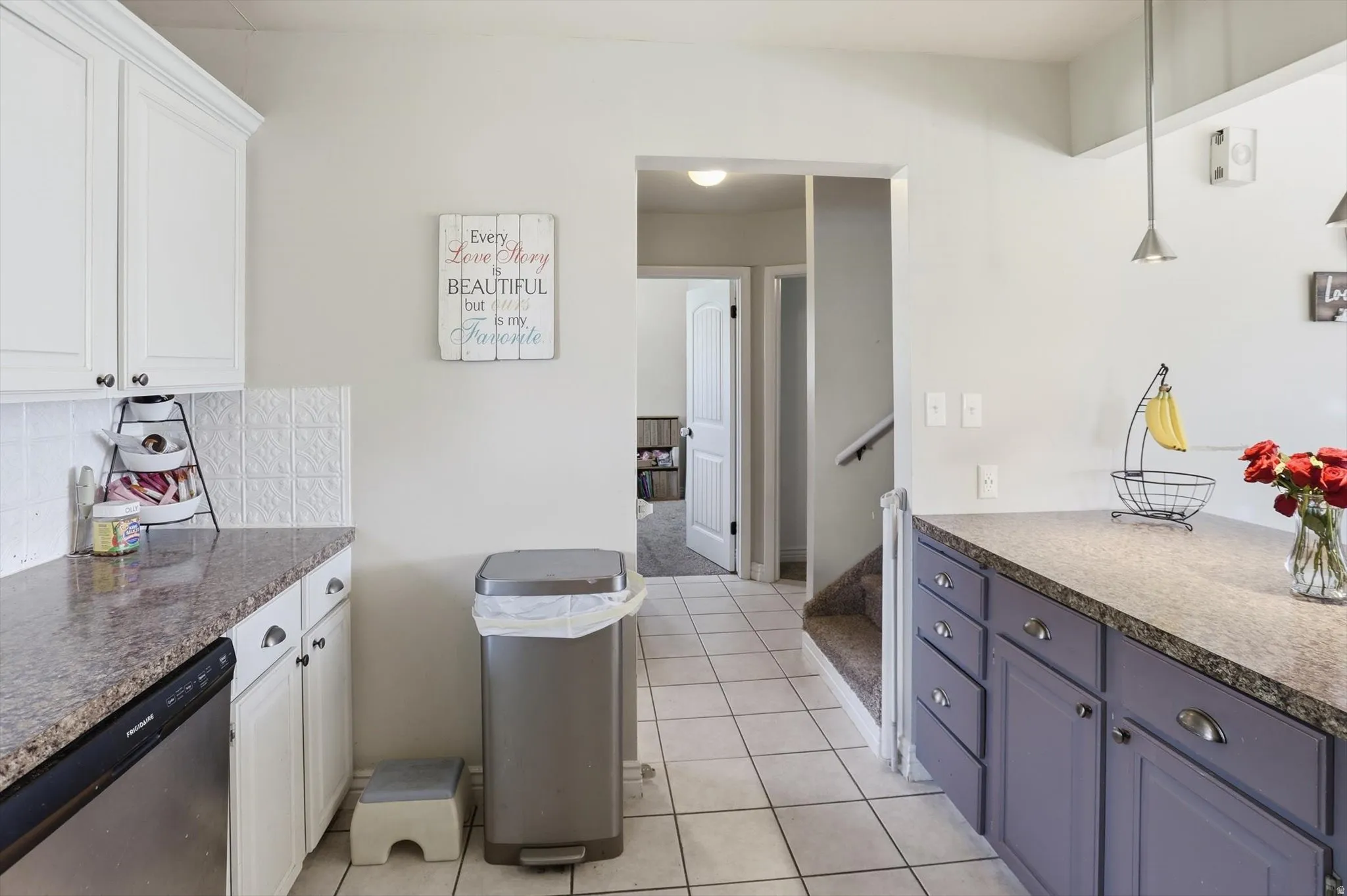 Kitchen featuring white shaker-style upper cabinetry, contrasting purple lower cabinetry, and granite-look countertops