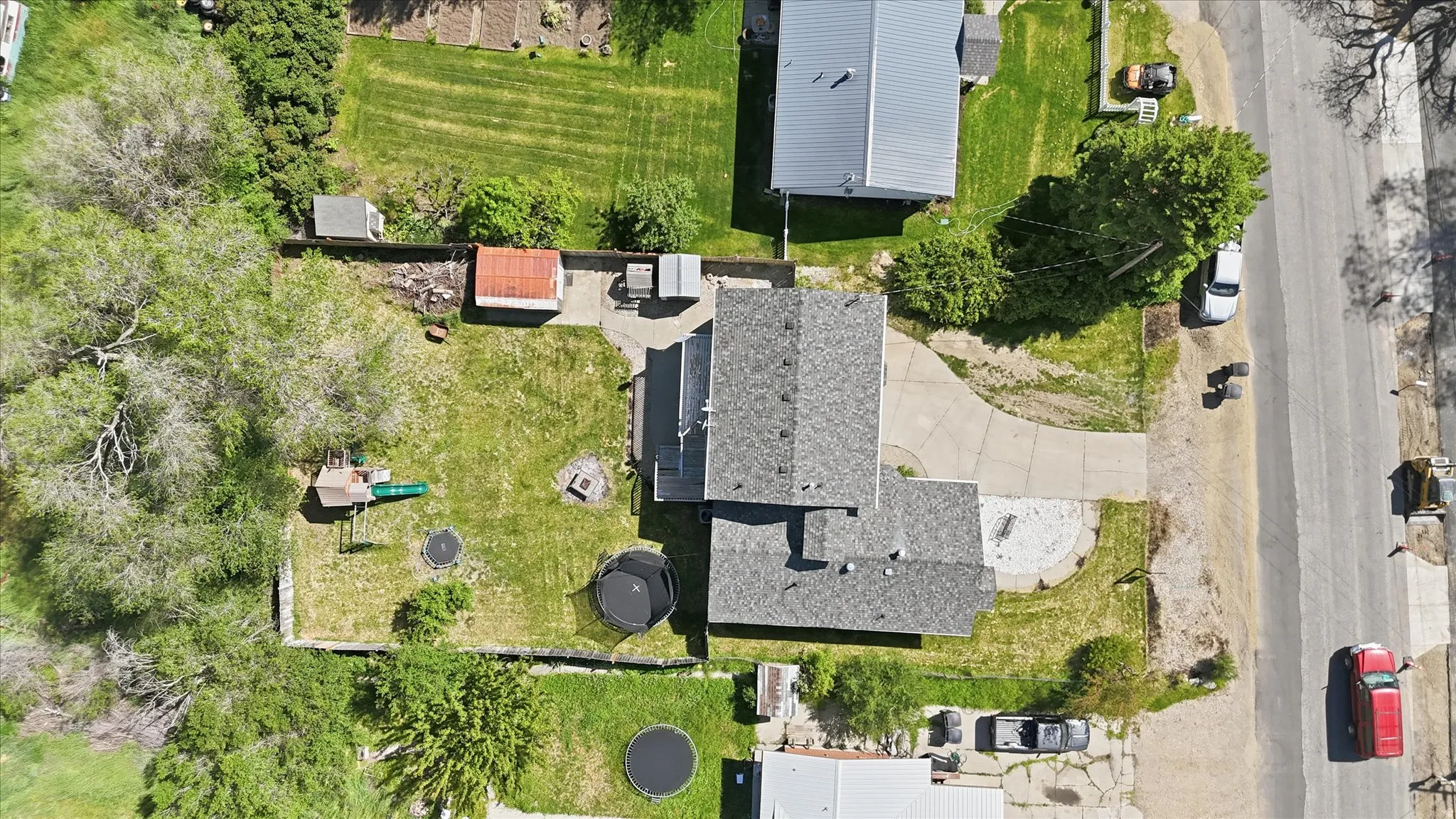 Spacious property featuring a main house with a gray shingle roof, a detached structure with a similar roofline, and a concrete driveway