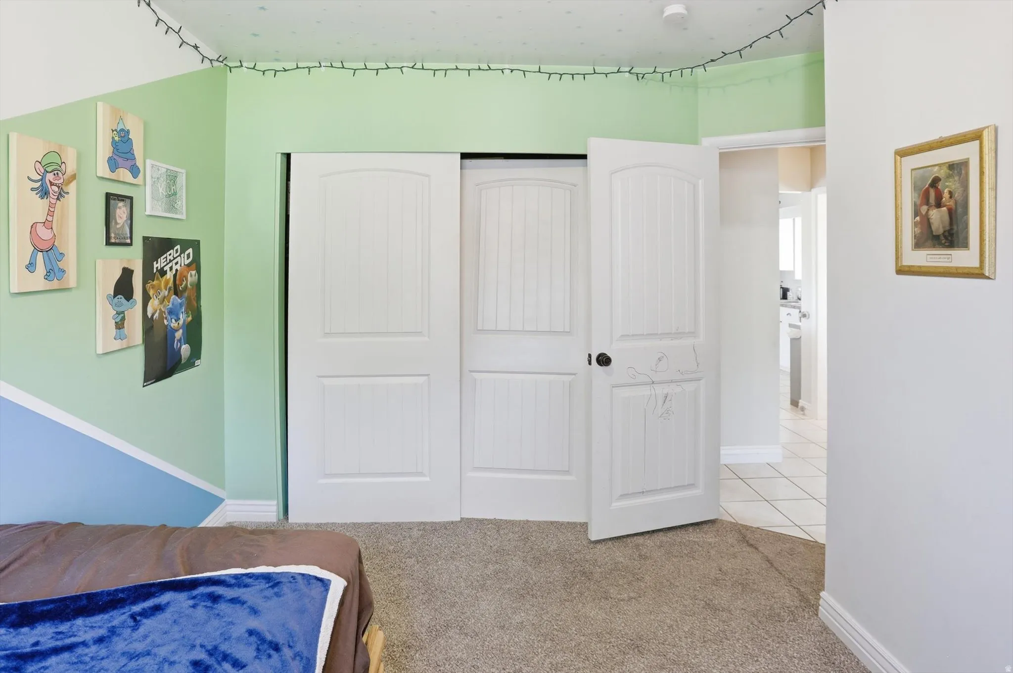 Bedroom featuring white trim, a double-door closet with paneled doors, and plush carpet flooring
