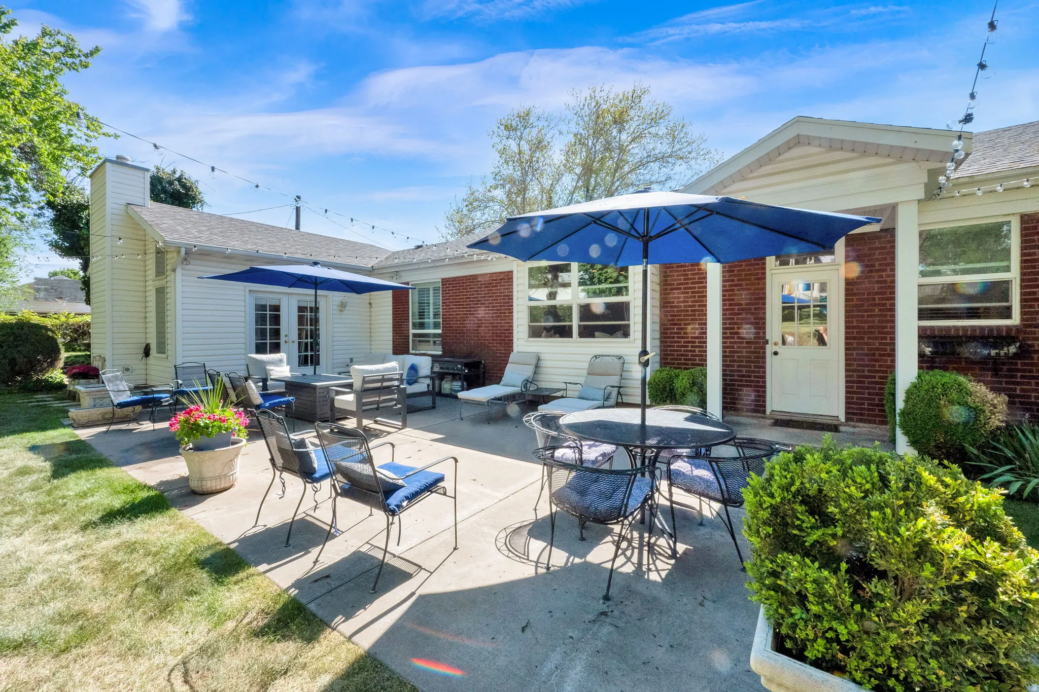 Expansive concrete patio offering direct access to the interior via French doors and a single entry door