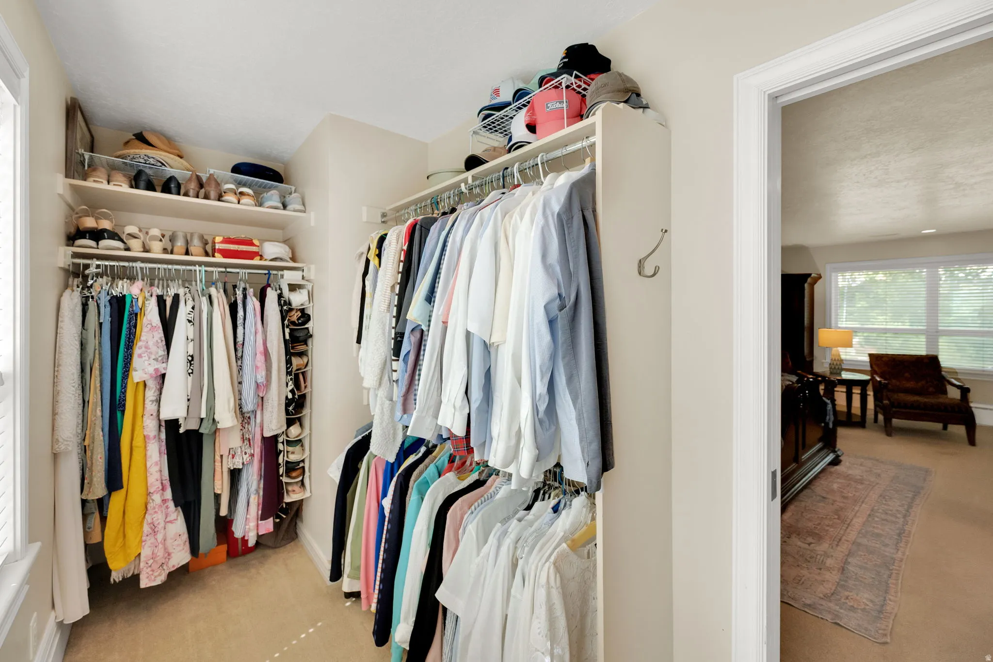 Walk-in closet featuring extensive built-in shelving and multiple hanging rods