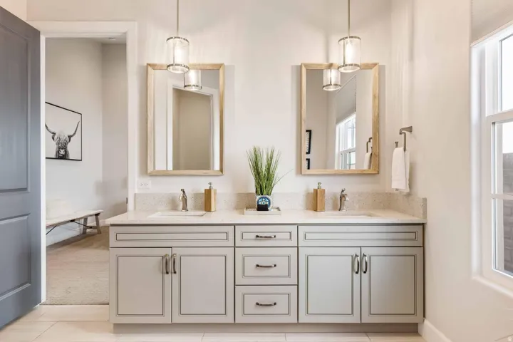 Double vanity featuring light grey cabinetry, dual undermount sinks, and a speckled countertop