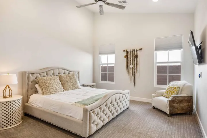 Vaulted ceilings enhance this carpeted room featuring recessed lighting and a ceiling fan