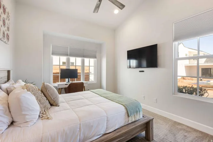Bright bedroom featuring a vaulted ceiling and an integrated ceiling fan