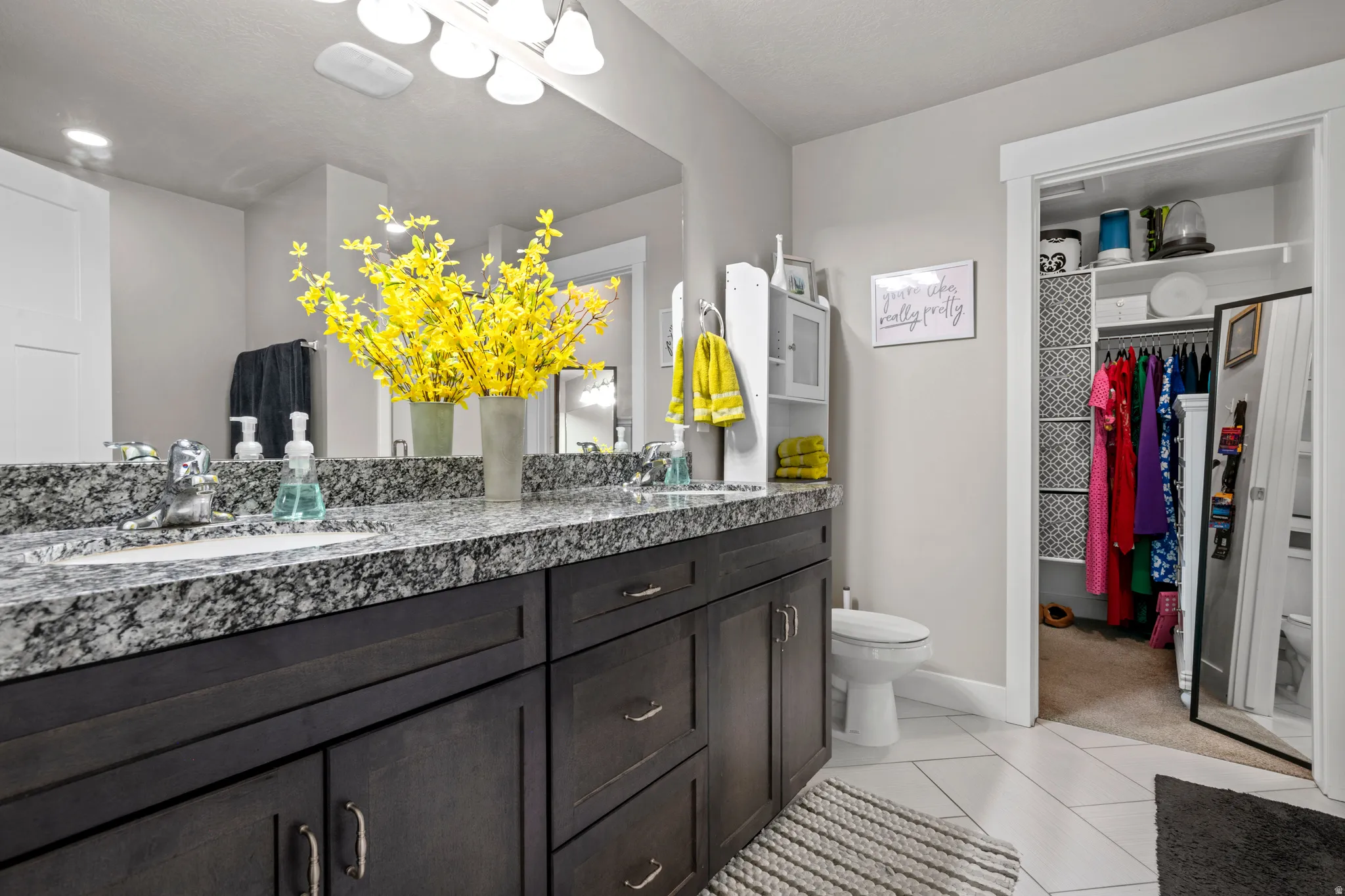 Spacious primary bathroom featuring a dual vanity and herringbone tile