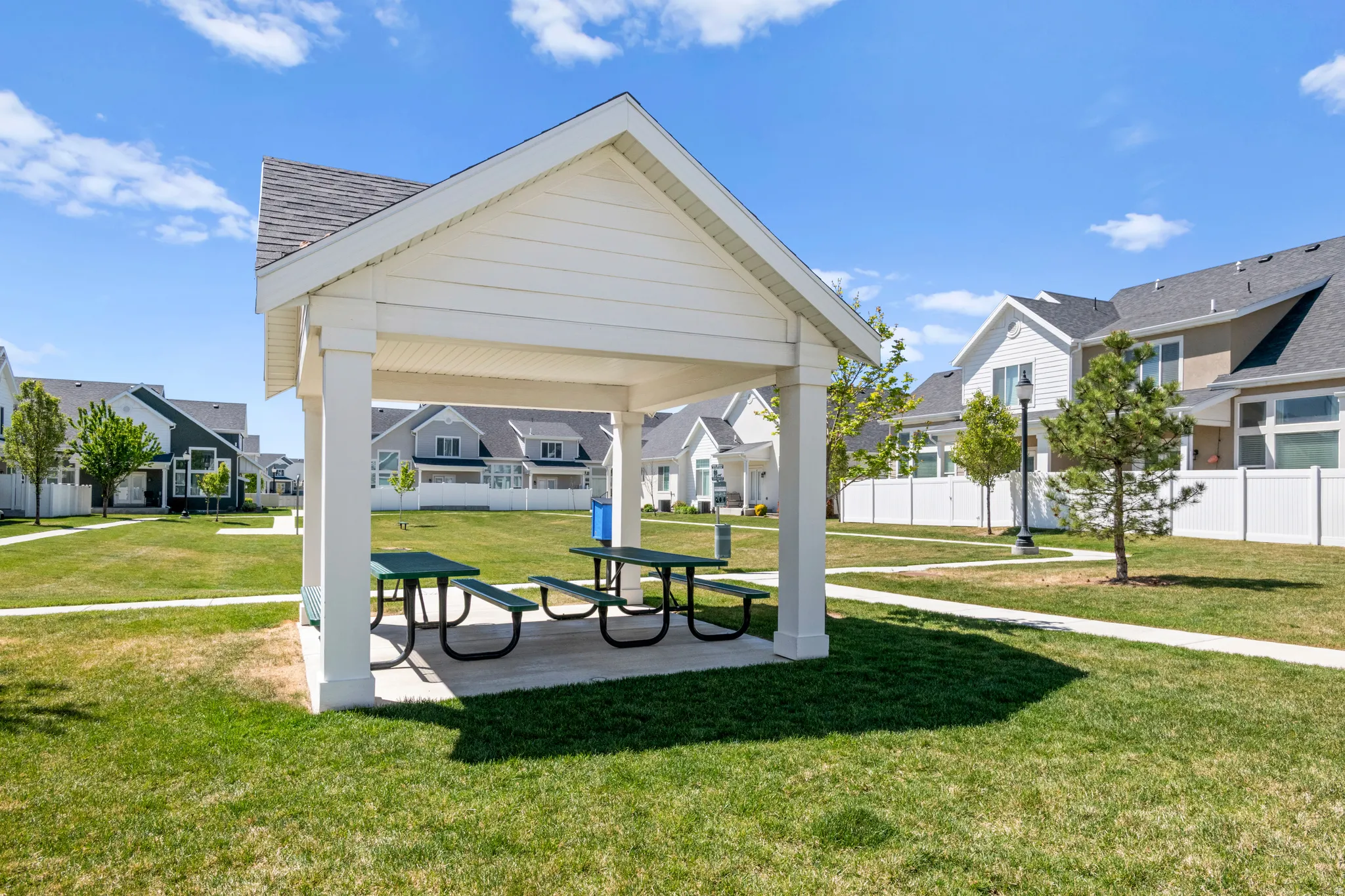 Community gazebo with picnic tables and green space just behind home