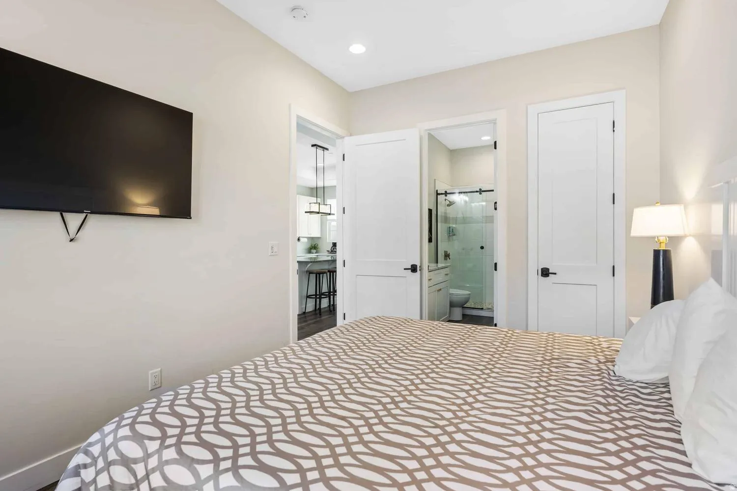 Interior room featuring recessed lighting, a built-in wall-mounted television, and a white paneled door with black hardware