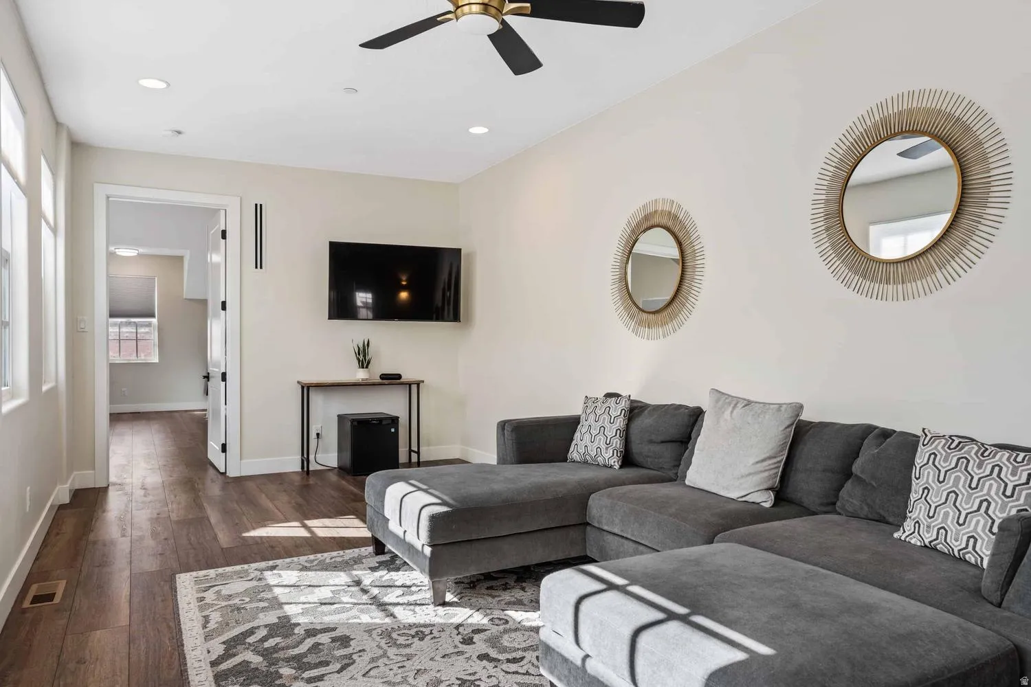 Spacious living area featuring wood-finish flooring, recessed lighting, and a modern ceiling fan