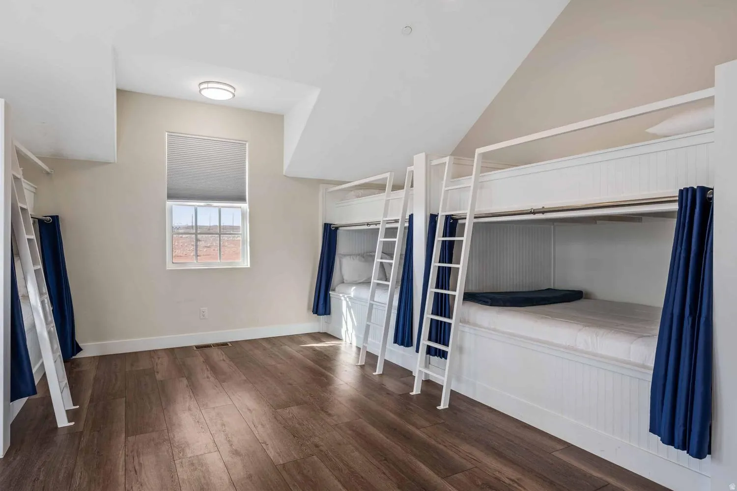 Built-in bunk beds featuring shiplap detailing and privacy curtains