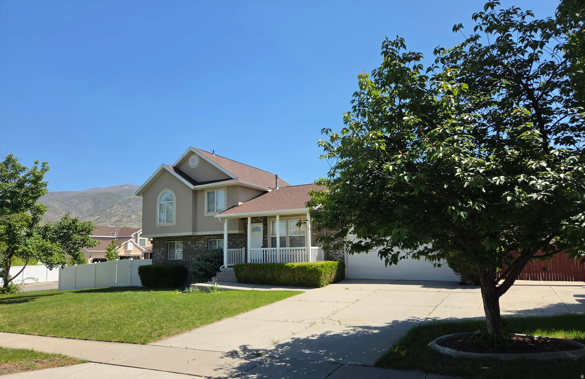 Two-story residence featuring a covered front porch, a two-car garage, and a concrete driveway