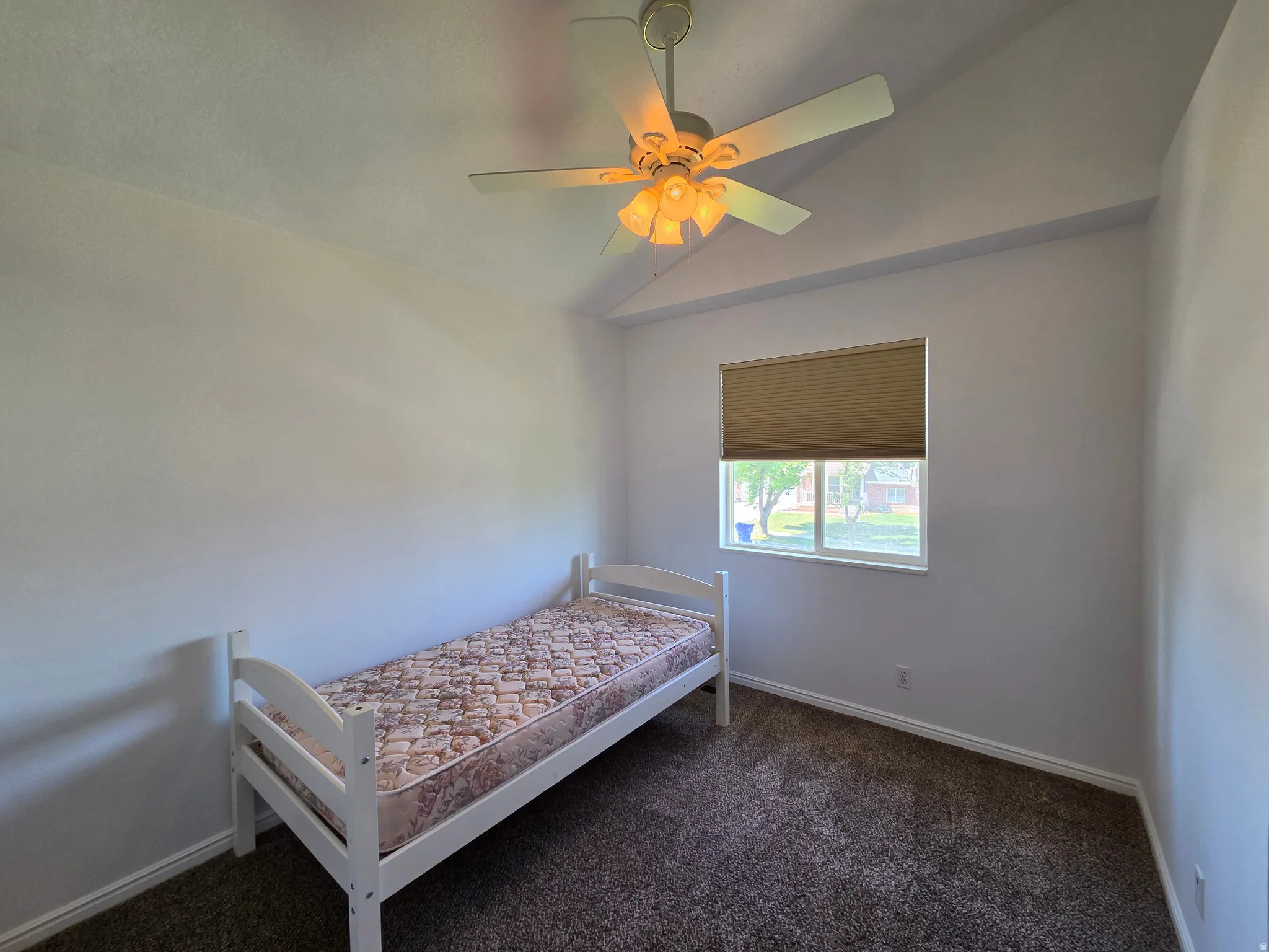 Room featuring vaulted ceilings and a ceiling fan with integrated lighting