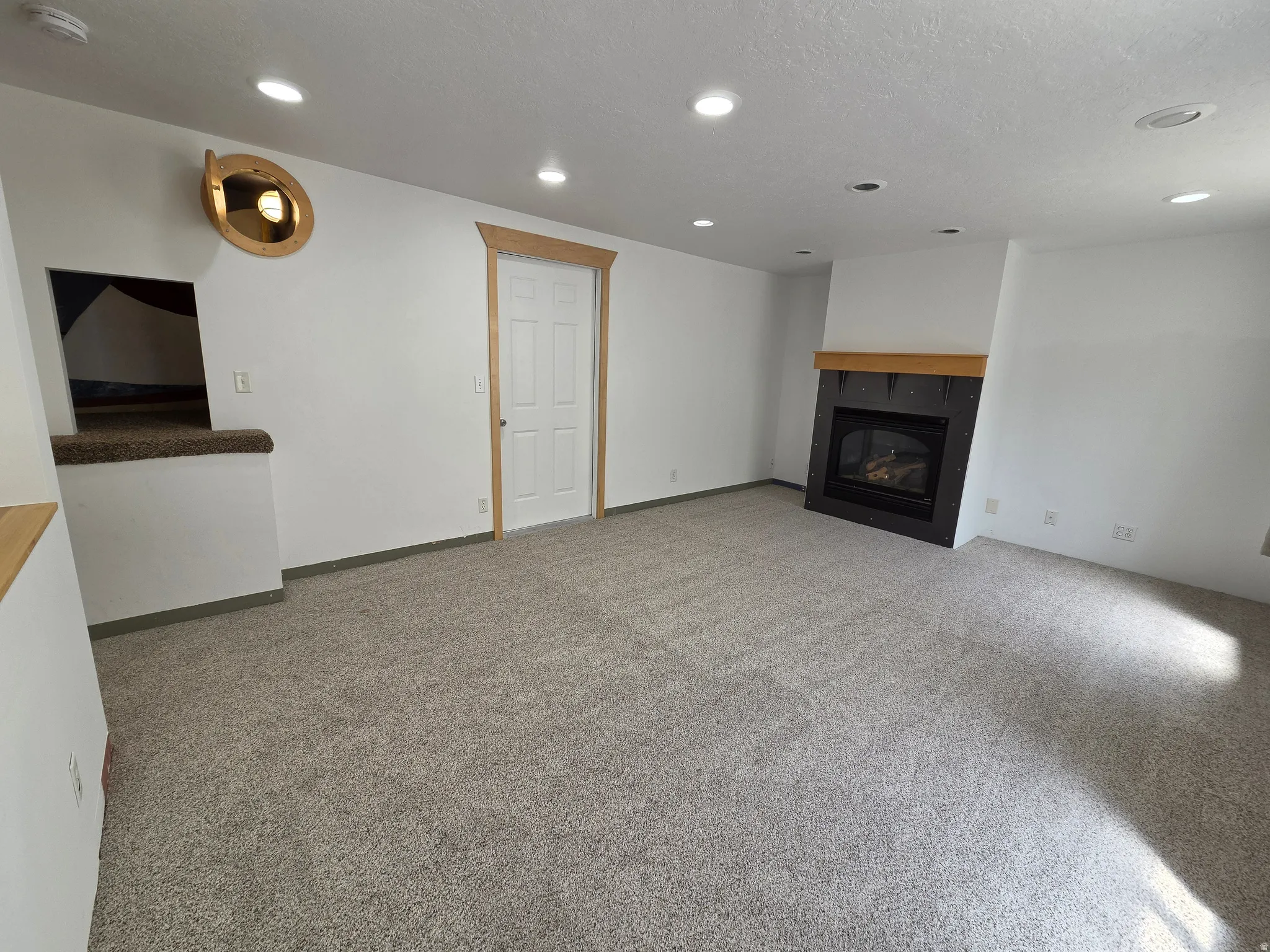 Spacious room with a gas fireplace featuring a wood mantel