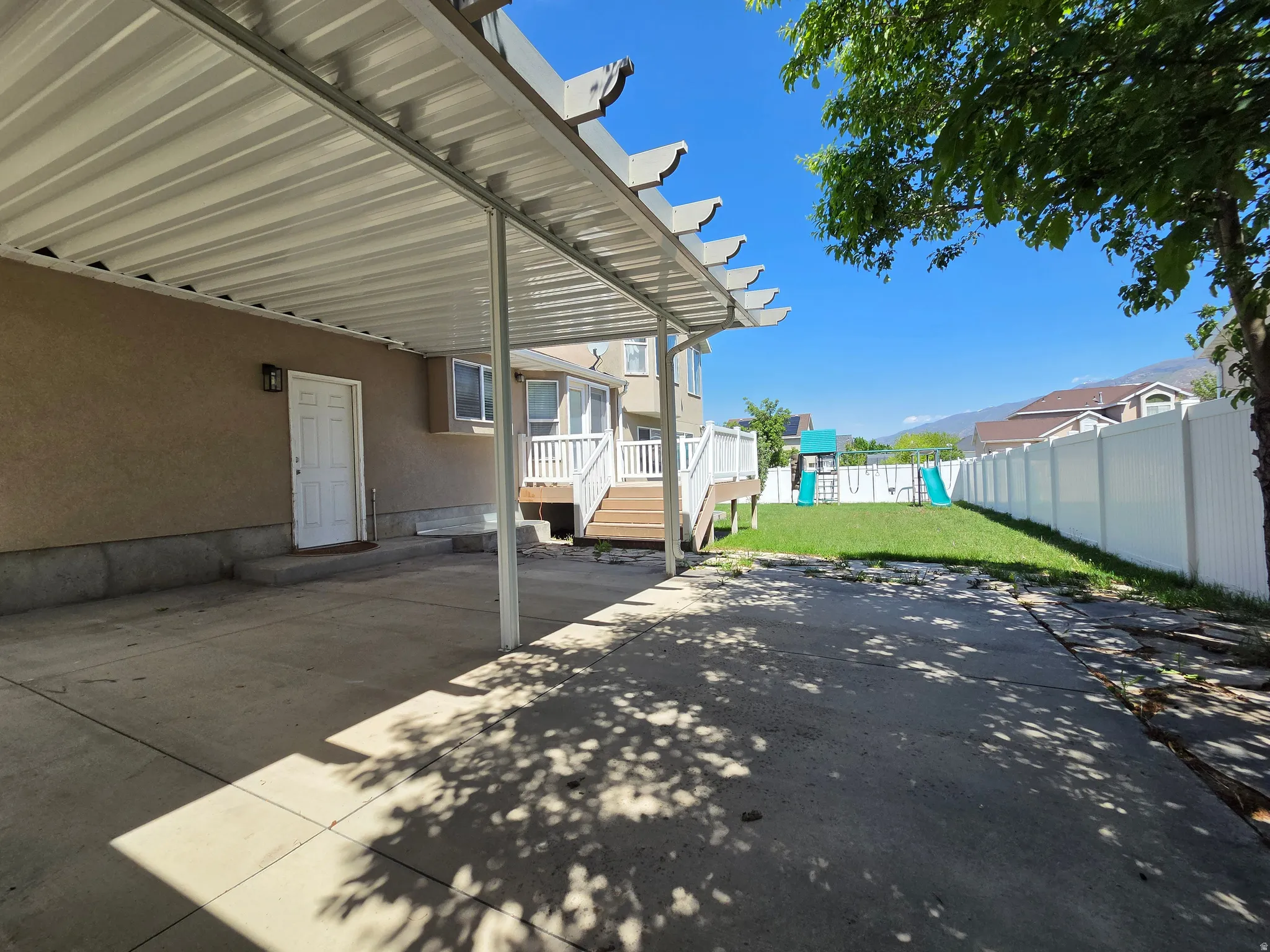 Expansive concrete patio with a full-coverage aluminum pergola