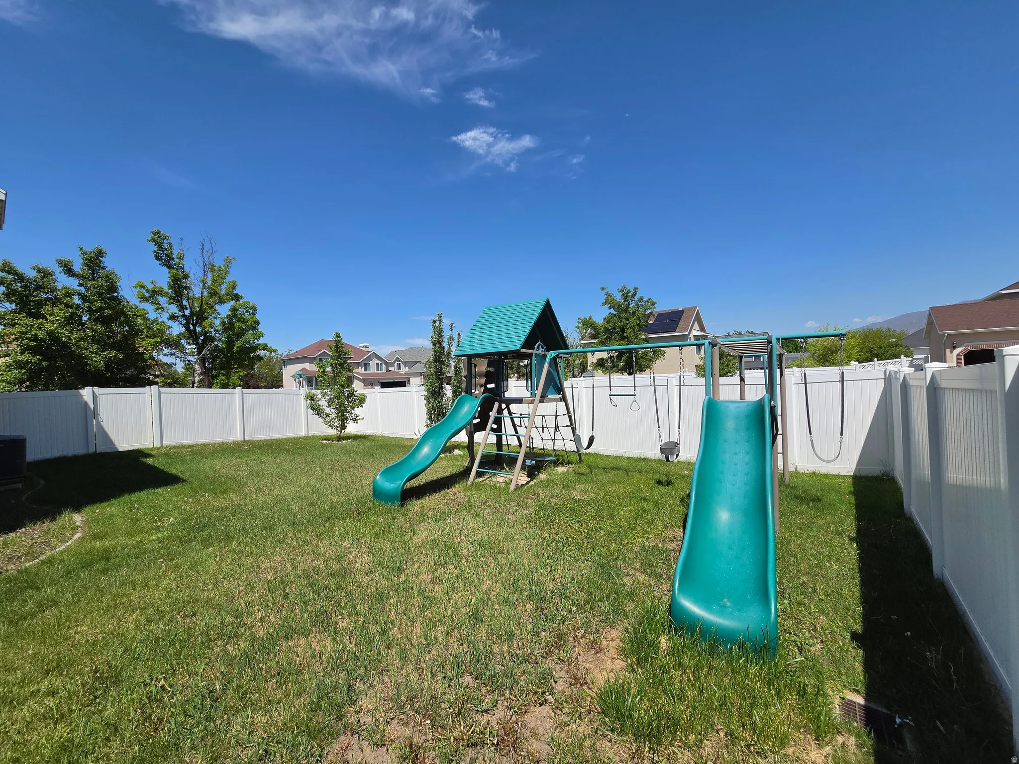 Expansive backyard with a manicured lawn, complete with a vinyl privacy fence