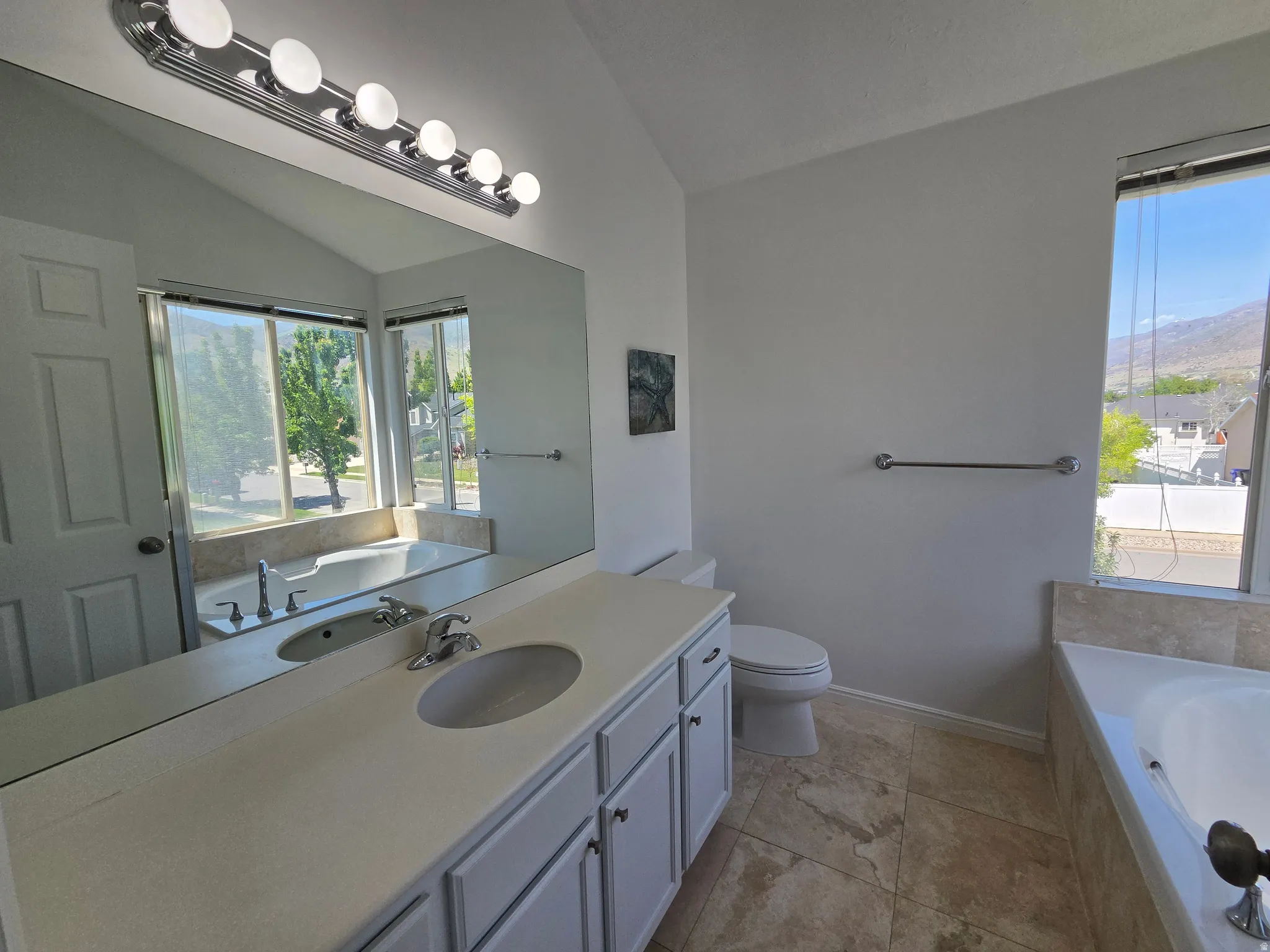 Bathroom featuring a built-in soaking tub, dual vanity with undermount sinks, and tile flooring