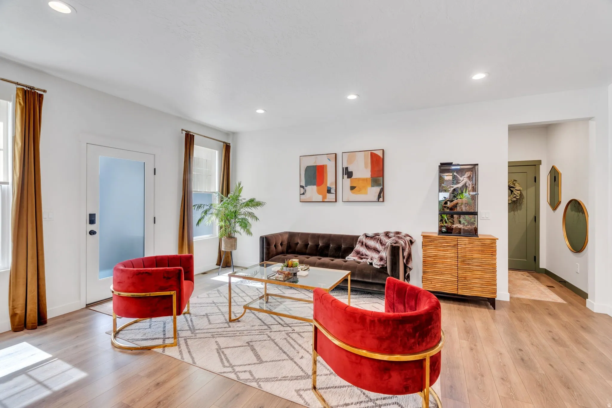 Bright living area featuring wood-finish flooring, recessed lighting, and a white interior door with frosted glass