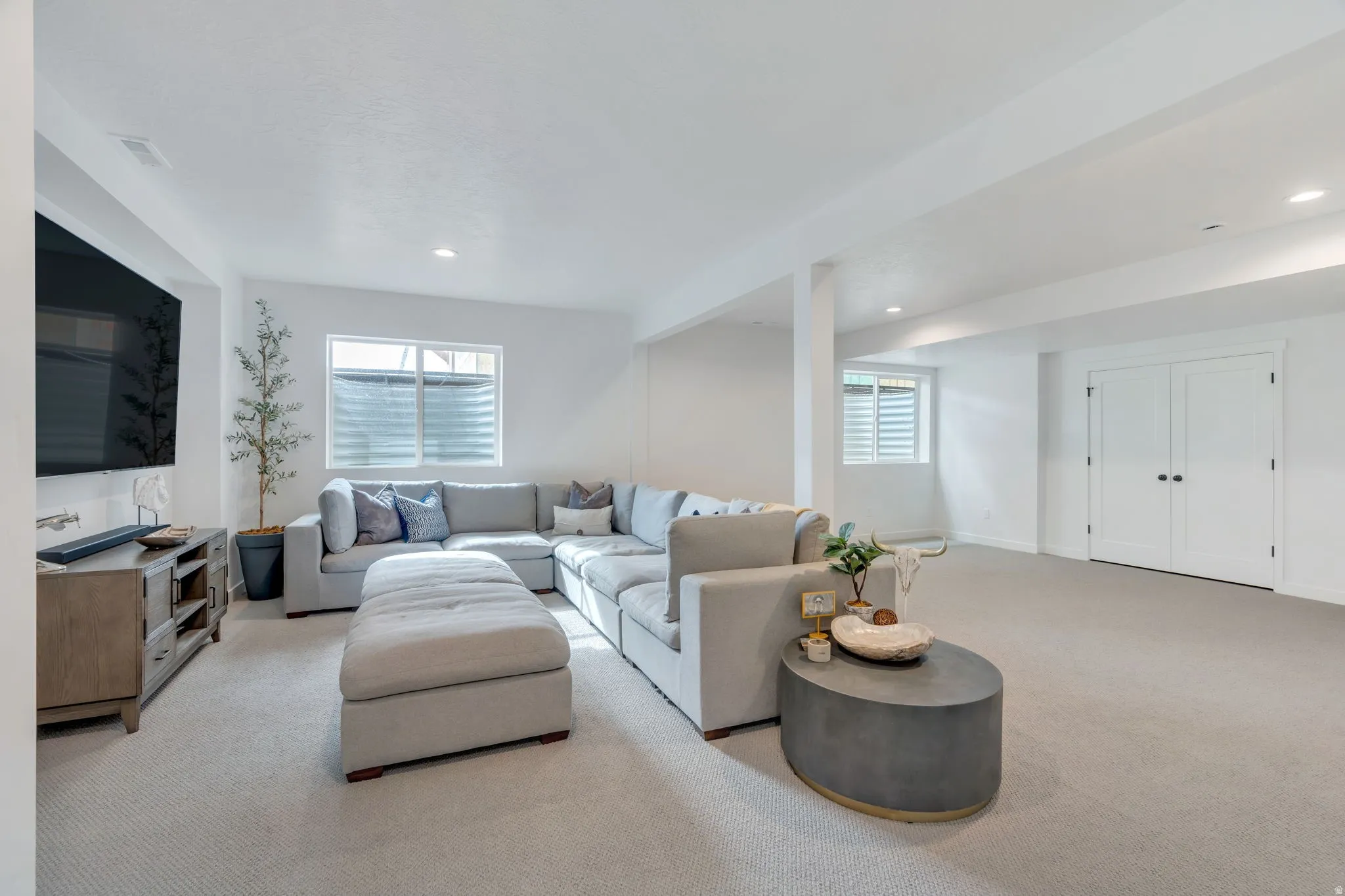 Spacious lower-level area featuring light-toned carpeting and recessed lighting