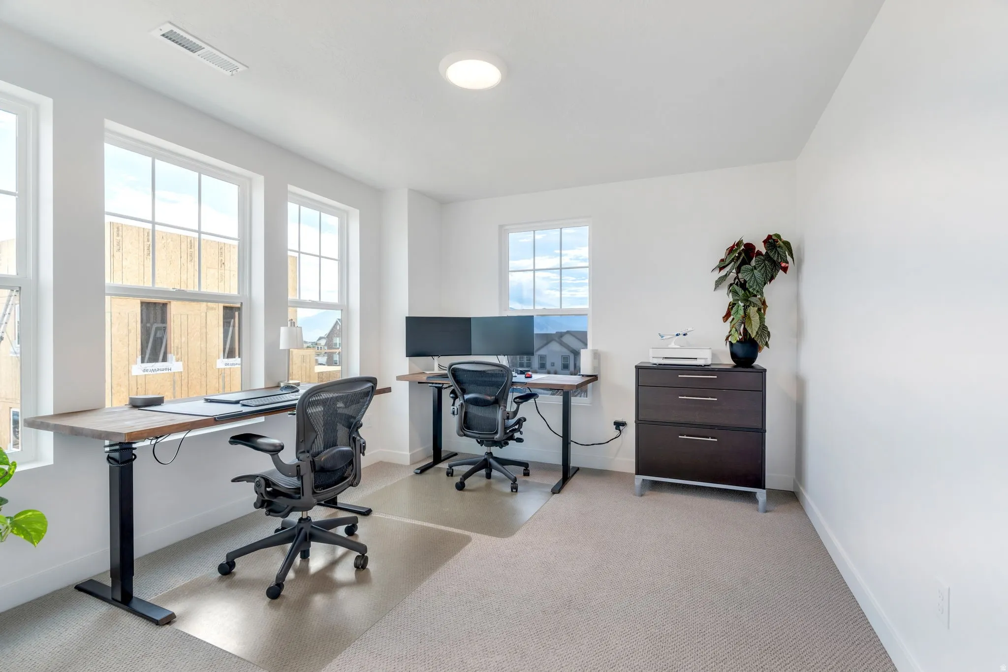 Bright room featuring multiple windows, recessed lighting, and light-colored carpeting