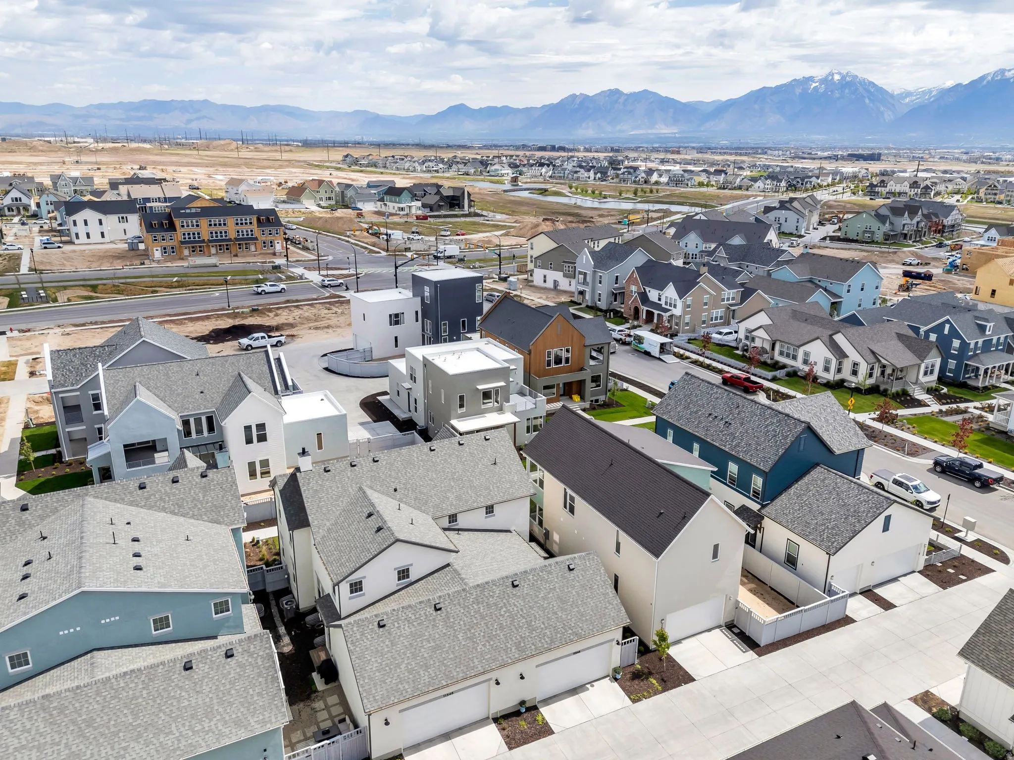 Aerial perspective showcasing a developing residential community with varied architectural styles, asphalt shingle roofs, and concrete driveways