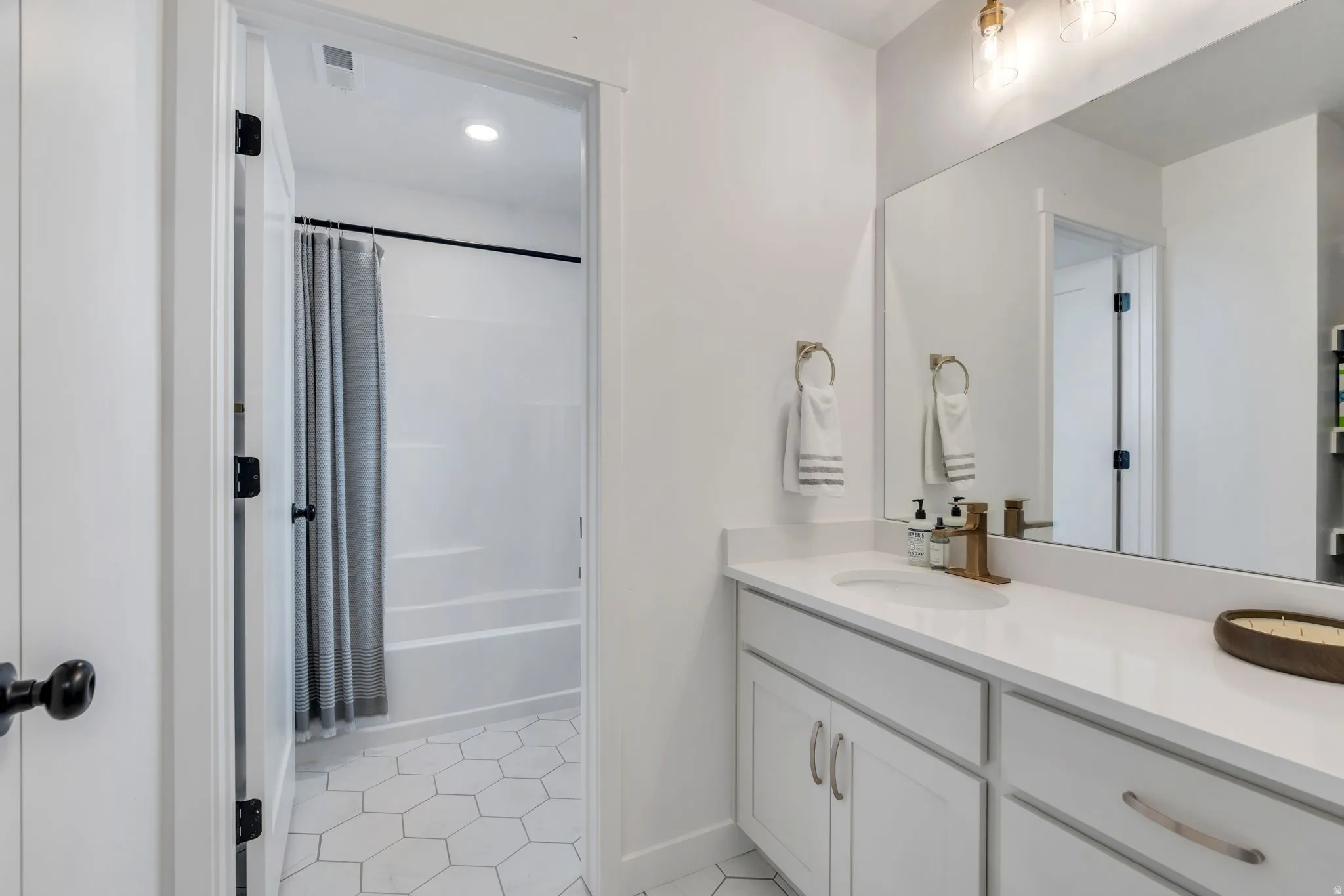Bathroom featuring a white vanity with an integrated sink and light-colored countertop