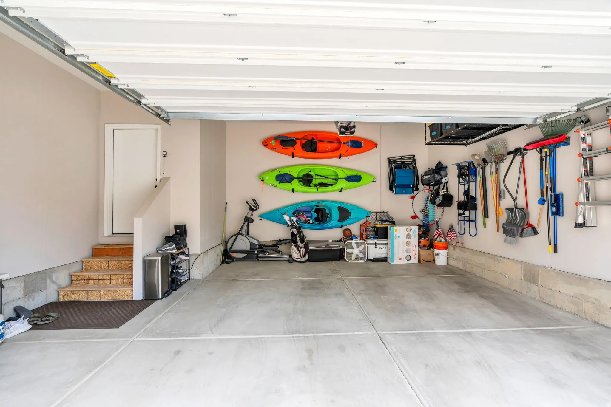 Spacious garage featuring a concrete floor, light-toned walls, and a white interior door