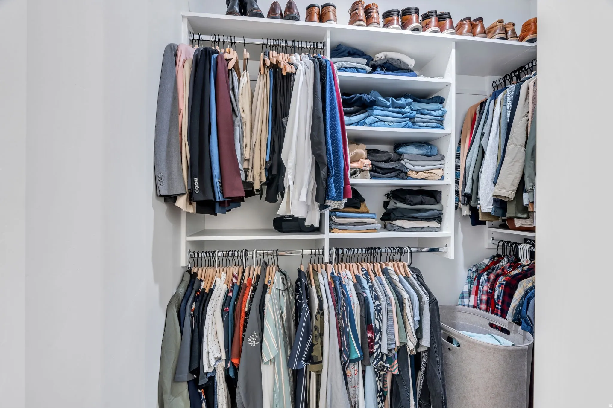 White custom closet system featuring multiple hanging rods and integrated shelving