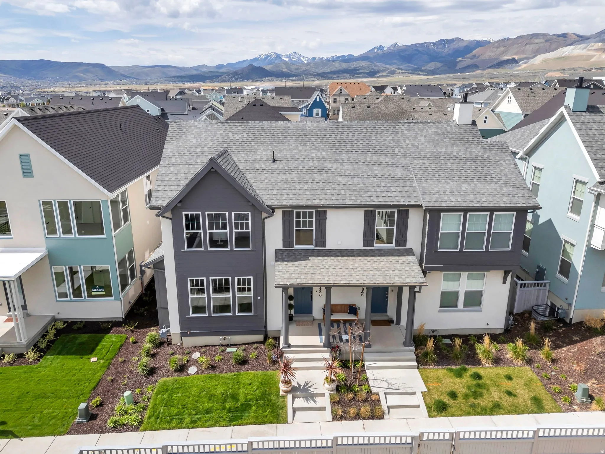 Contemporary two-story residence with a gray shingle roof and a covered porch