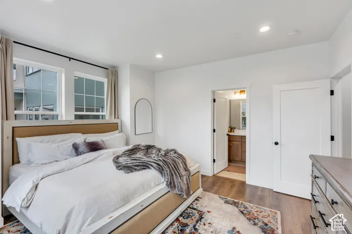 Bedroom featuring wood-finish flooring, recessed lighting, and multi-pane windows with grid detailing