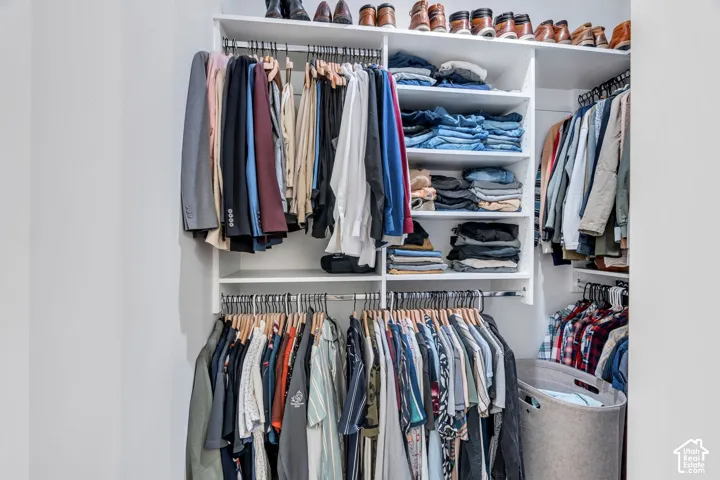 White custom closet system featuring multiple hanging rods and integrated shelving