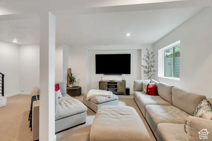Neutral-toned carpeting, recessed ceiling lighting, and a recessed wall niche featuring built-in media capability