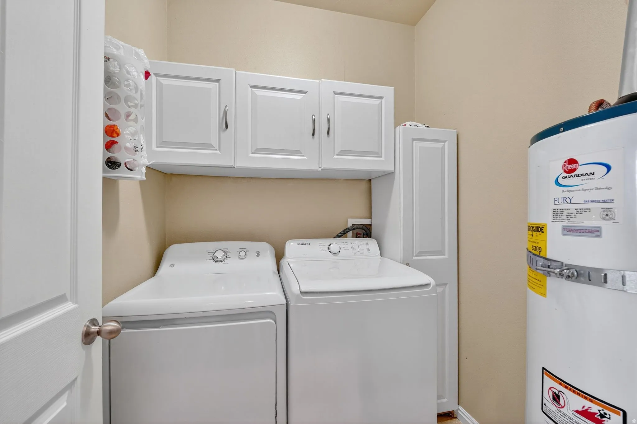 Laundry area featuring white cabinetry and light-colored walls