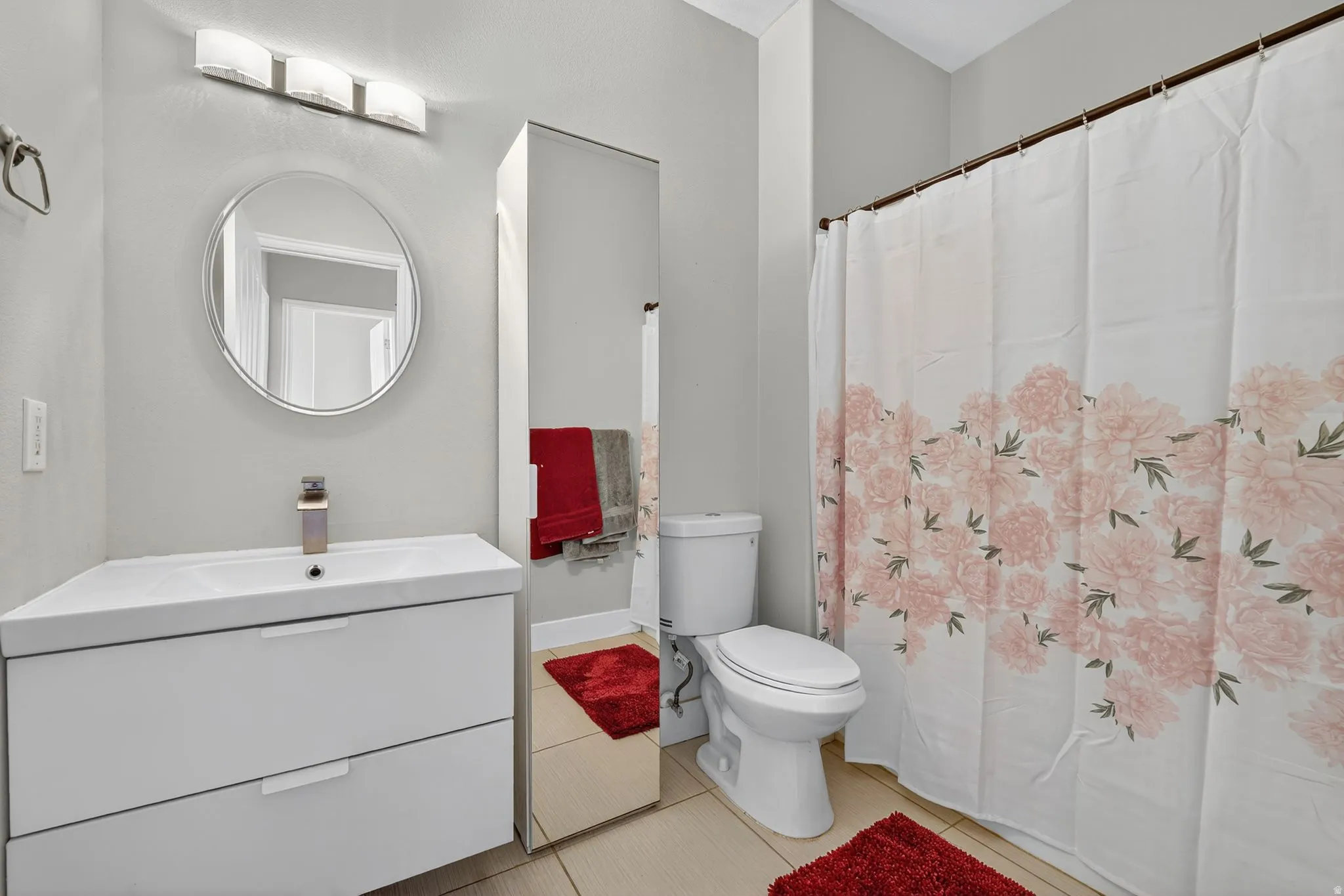 Modern bathroom featuring a floating white vanity with integrated sink and chrome faucet