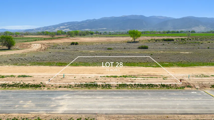 Expansive 3.5-acre lot featuring a paved road frontage and distant mountain scenery