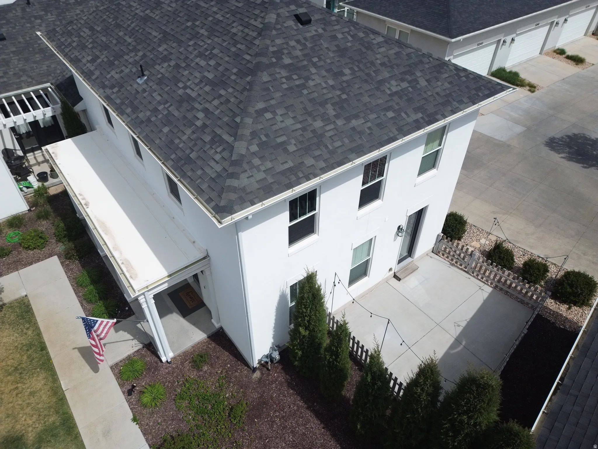 Two-story residence featuring a dark shingle roof and white exterior