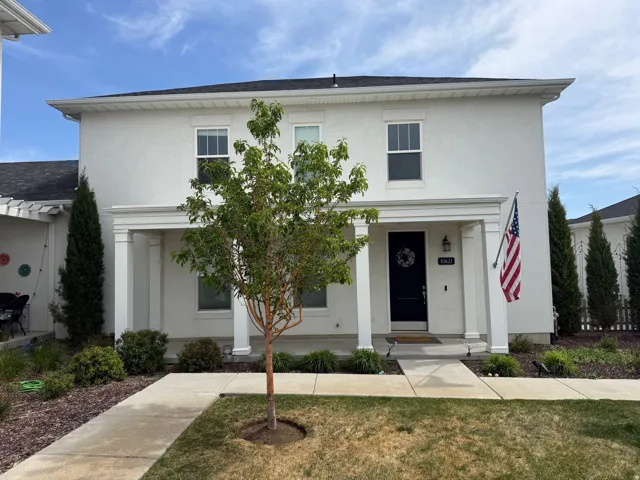 Stucco exterior with a covered porch featuring prominent columns