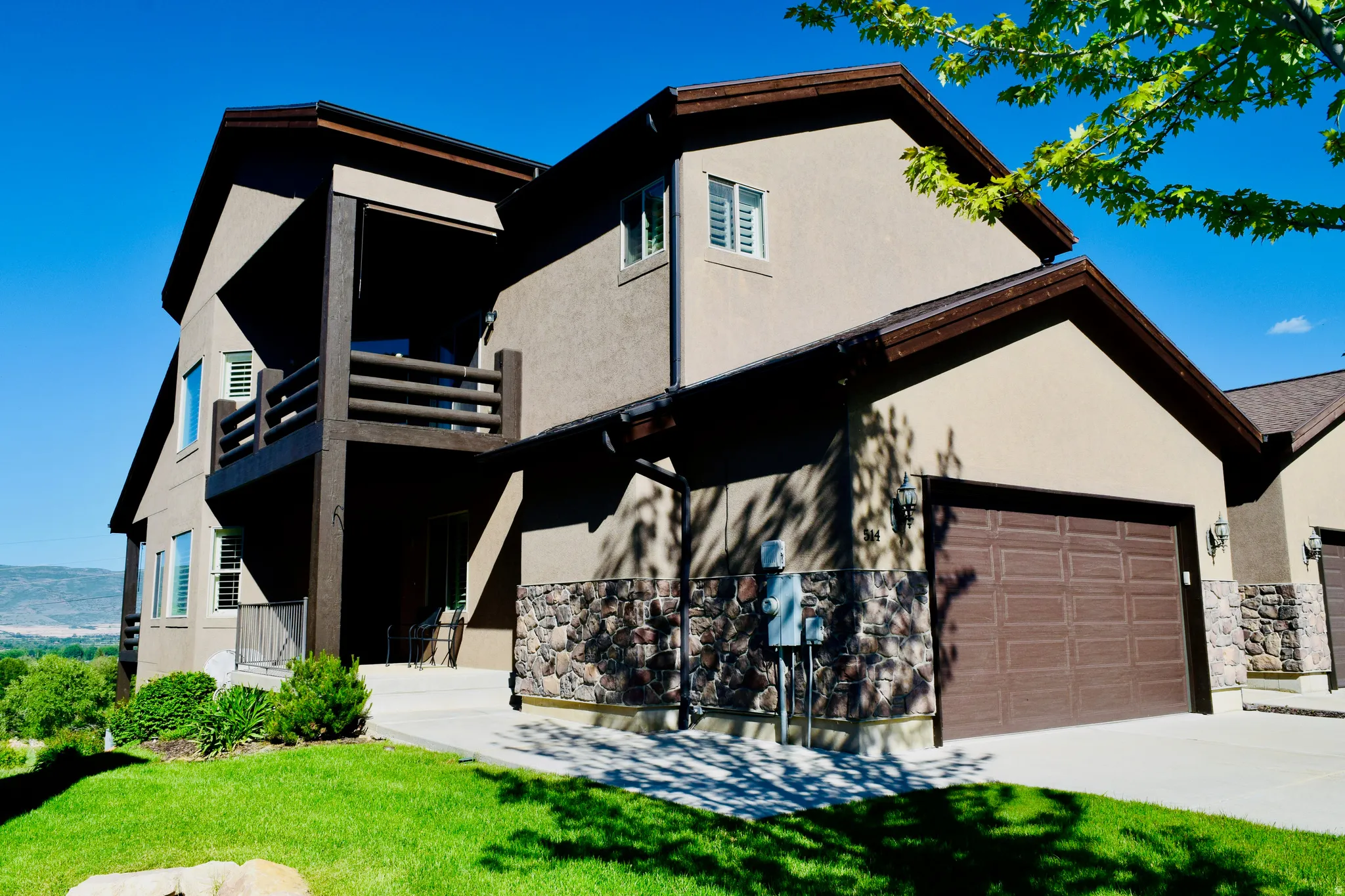 Two-story exterior with stucco siding and stone accents