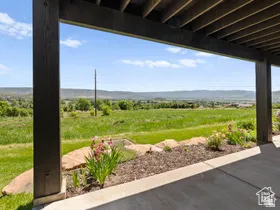 Covered patio featuring a concrete surface, dark wood-finish ceiling, and support columns