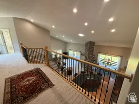 Loft overlooking a vaulted living space with recessed lighting