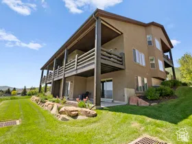 Multi-level stucco exterior with two expansive decks featuring dark wood railings