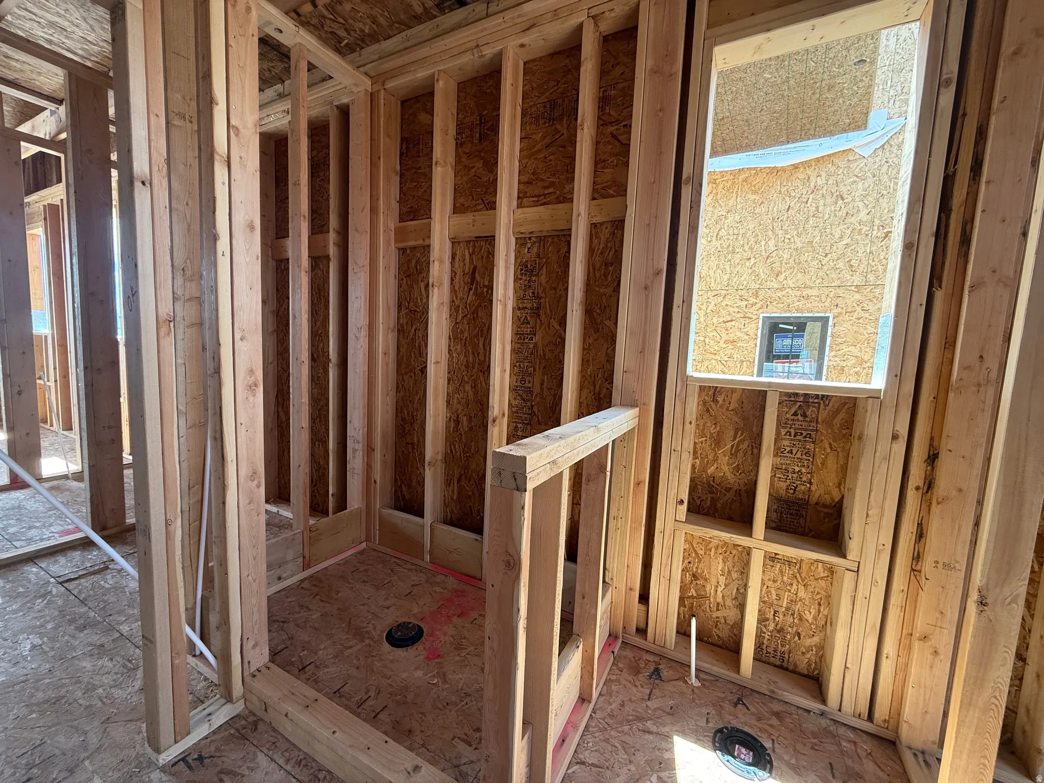 Framed shower enclosure with a floor drain and a framed window opening