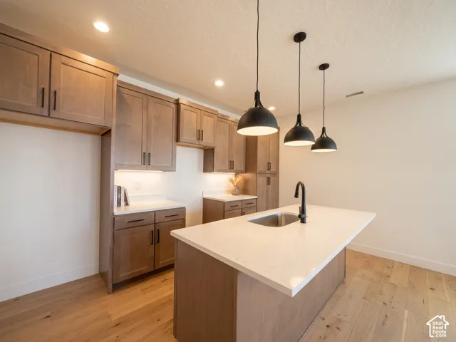 Warm wood cabinetry, black hardware, and quartz countertops
