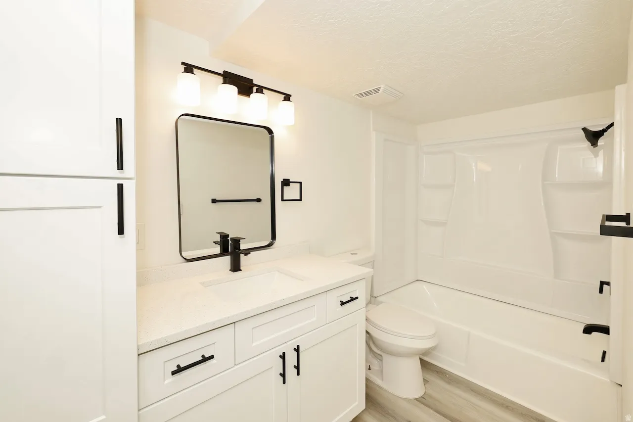 Contemporary bathroom featuring a white vanity with a light-colored countertop, a rectangular black-framed mirror, and a modern black faucet