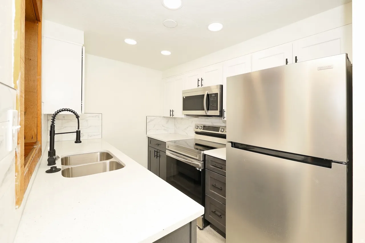 Modern kitchen featuring white shaker upper cabinetry and contrasting gray lower cabinetry