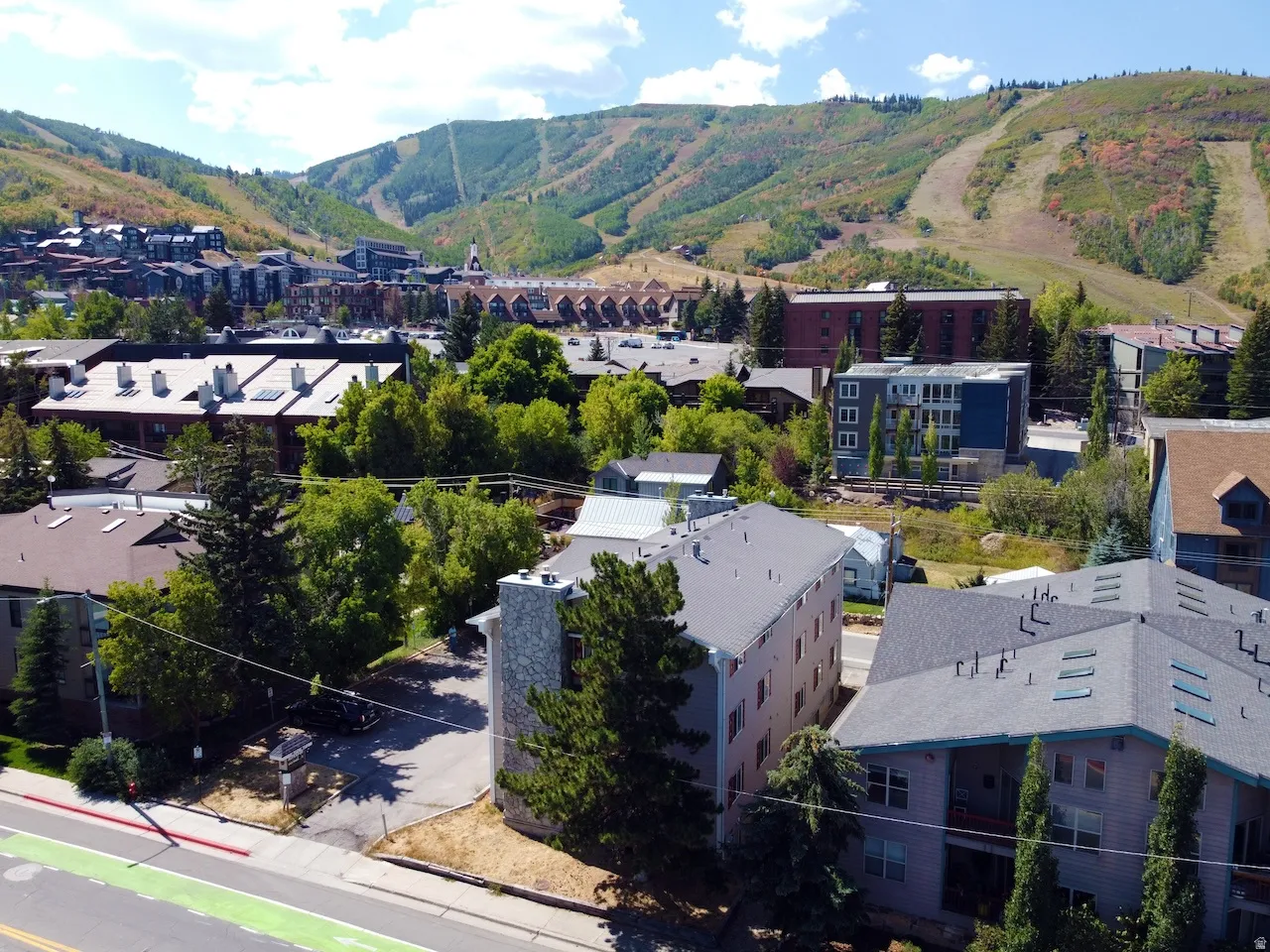Hillside setting with mountain backdrop and extensive tree coverage