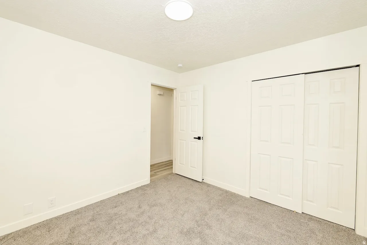 Neutral-toned room with light gray carpet flooring and white baseboards