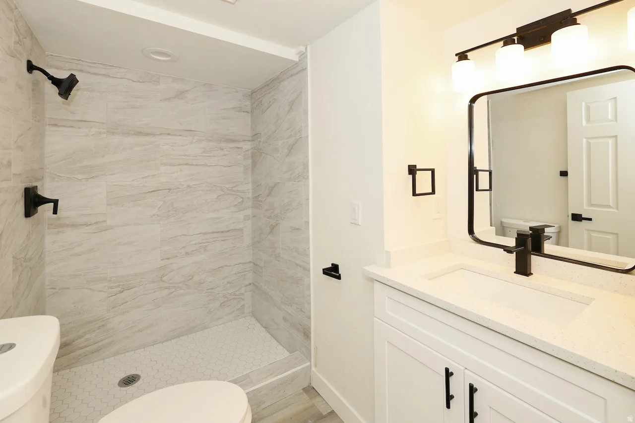 Walk-in shower with large format tile surround and hexagonal floor tiles