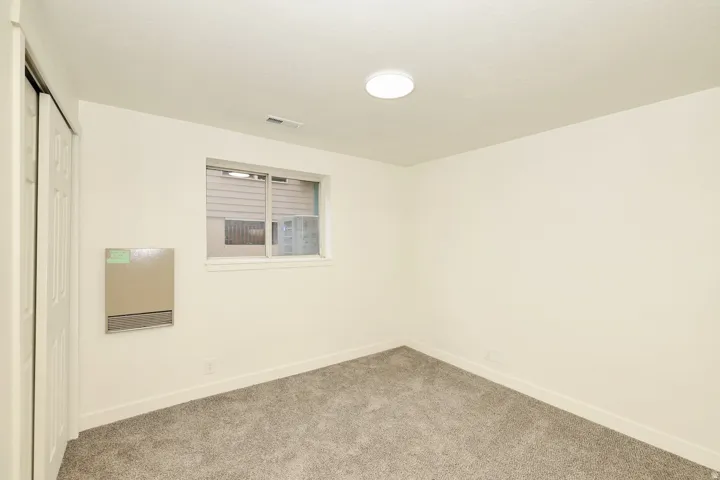Interior space featuring light gray carpet, white walls, and a white ceiling with flush-mount lighting