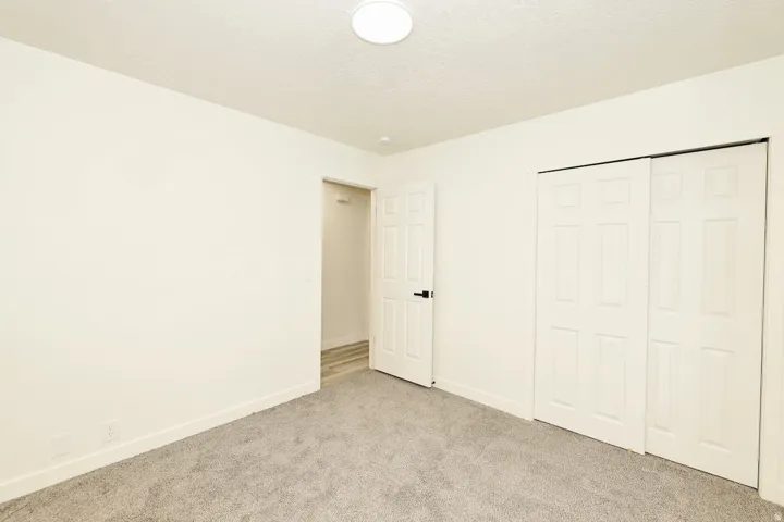 Neutral-toned room with light gray carpet flooring and white baseboards