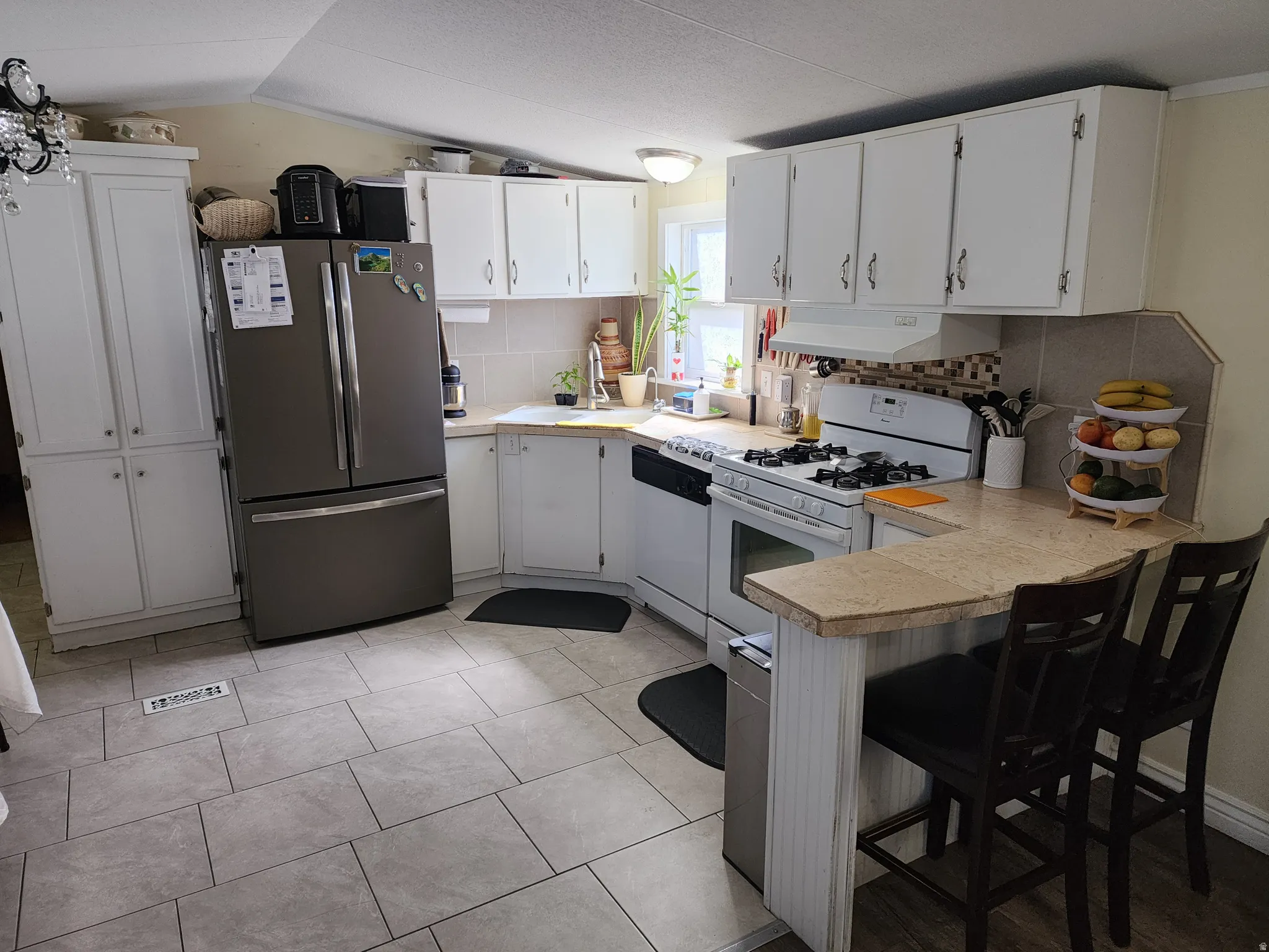 Kitchen featuring white cabinetry and tile backsplash