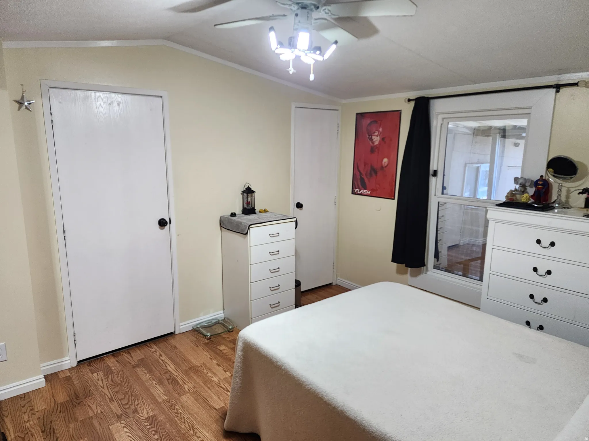 Bedroom with light-colored walls and wood-finish flooring